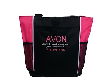 May include: Black tote bag with pink accents and white piping. The bag has a mesh pocket on each side and features the text "AVON Want to make money... Join Leadership 715-505-7729" embroidered in pink.