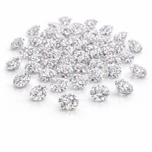 May include: A scattering of brilliant-cut diamonds on a white background. The diamonds are clear and reflect light, creating a sparkling effect. The image highlights the clarity and brilliance of the gemstones.