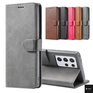 Puede incluir: Funda de teléfono de cuero gris con cierre magnético y detalles de costura. La funda se muestra en varios colores, incluyendo marrón, negro, rosa y gris. La funda del teléfono está diseñada para proteger el teléfono y se puede plegar para actuar como soporte.