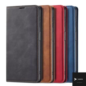 May include: Four rectangular wallet-style phone cases standing upright in a row. The cases are coloured black, brown, red, and blue, each featuring a smooth matte finish, visible stitching along the edges, and side buttons. A logo reads CASETEC.