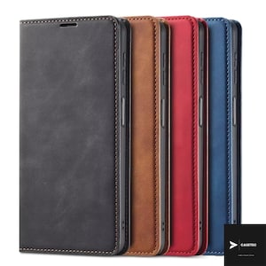 Könnte beinhalten: Eine Reihe von Leder-Handyhüllen in verschiedenen Farben: Schwarz, Braun, Rot und Blau. Jede Hülle hat einen genähten Rand und einen Magnetverschluss. Die Hüllen sind zum Schutz des Telefons und für einen stilvollen Look konzipiert.