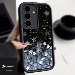 May include: Black phone case with a floral design. The case features a black border and a black background with white and blue flowers. The brand name "CASETEC" is visible in the bottom left corner.