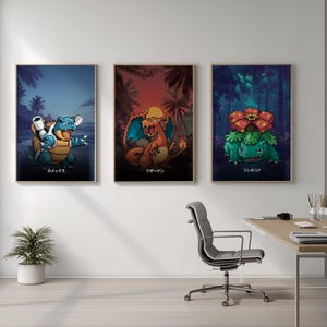 May include: Three framed art prints featuring pixelated illustrations of Pokémon characters. Each print has a dark background with palm trees or a forest. Japanese text is at the bottom of each print. The prints are displayed above a desk.