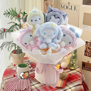 May include: A bouquet of plush toys in pastel colors, including blue, pink, and yellow, wrapped in white paper and tied with a pink ribbon. The toys have animal-like features and star accents. The word "VOGUE" is visible in the background.