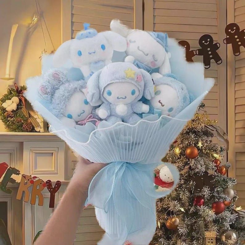 May include: A bouquet of plush toys in shades of blue and white. The bouquet features several stuffed animal characters wrapped in light blue paper and tied with a matching ribbon. The background includes a Christmas tree and festive decorations.