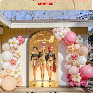 Op de afbeelding: Een boogvormige achtergrond met drie geanimeerde figuren in goudkleurige en zwarte outfits met de tekst Samantha 8 turns. Het display is omringd door een ballonnenboog in roze, crème en witte tinten met bloemvormige ballontrossen.
