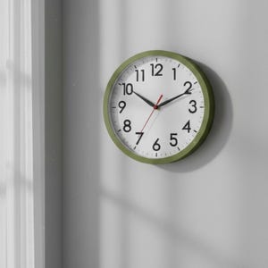May include: A round wall clock with a white face, black numerals, and black hands. The second hand is red. The clock has a green frame and is mounted on a gray wall.