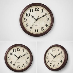 May include: A round wall clock with a dark brown frame and a cream-colored face. The clock features black numerals and hands, with the word "QUARTZ" printed below the center. The clock is approximately 10 inches in diameter.