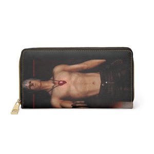 Könnte beinhalten: Schwarze Geldbörse mit goldenem Reißverschluss und einem gedruckten Bild einer Person mit einer roten Edelsteinkette. Die Geldbörse ist rechteckig und hat einen goldenen Reißverschluss. Das Bild auf der Geldbörse zeigt eine Person mit einer roten Edelsteinkette.