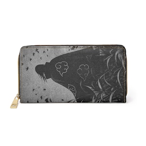 Peut inclure: Portefeuille noir et blanc avec une silhouette de personnage ornée de symboles de nuages. Le portefeuille est doté d'une fermeture éclair dorée et d'une surface texturée. Le motif est posé sur un fond gris avec un vol d'oiseaux.