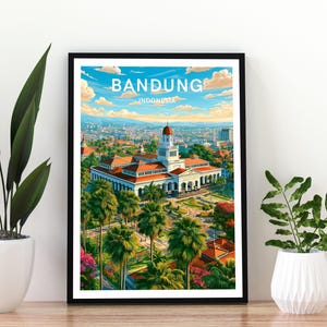 May include: A framed travel poster featuring the Gedung Sate building in Bandung, Indonesia. The illustration displays the white colonial-style architecture with a red roof, surrounded by lush green palm trees, gardens, and a blue sky with clouds.