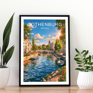Könnte beinhalten: Ein gerahmter Kunstdruck mit einer lebendigen Illustration eines Kanals in Göteborg, Schweden. Die Szene zeigt blaues Wasser mit kleinen Booten, Steingebäuden, grünen Bäumen und einen hellen Himmel mit Wolken. Der Text GOTHENBURG SWEDEN steht oben.