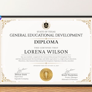 Op de afbeelding: Een ingelijst General Educational Development diploma van de staat Texas voor Lorena Wilson. Het document bevat zwarte tekst op een witte achtergrond met gouden decoratieve randen, een centraal gouden zegel en handtekeningen van William Smith en Arnold Reacherdson.