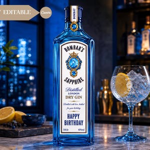 May include: A rectangular blue glass bottle of Bombar's Sapphire distilled London dry gin with a white label featuring a crown, a portrait, and the text Happy Birthday. Next to it is a stemmed glass filled with ice and a lemon slice.