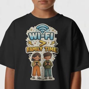 Op de afbeelding: Zwart T-shirt met de tekst "Wi-Fi > Family Time". Het ontwerp bevat een Wi-Fi-symbool, een groter-dan-teken en illustraties van twee kinderen die met hun telefoons bezig zijn. De kinderen dragen een bril en vrijetijdskleding.