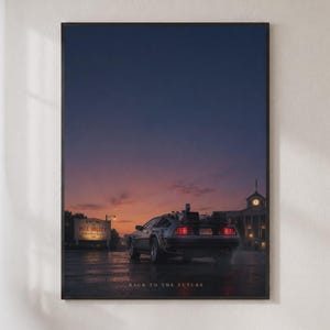 Puede incluir: Un póster vertical enmarcado que muestra un coche deportivo plateado aparcado en una carretera de asfalto mojado al atardecer. Un cartel dice Welcome to Hill Valley y se ve una torre del reloj. El texto Back to the Future aparece abajo.