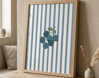 Può includere: Una stampa artistica incorniciata con un gruppo di mirtilli con foglie verdi su uno sfondo di strisce verticali blu e bianche. L'opera d'arte è in una cornice di legno ed è esposta su una superficie di legno.
