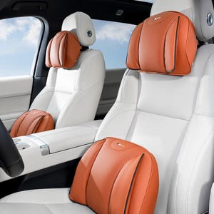 May include: A set of orange car seat cushions featuring a perforated center panel and smooth side bolsters. Each cushion includes a small logo emblem at the top center. The cushions are attached to the headrests and placed on the white car seats.