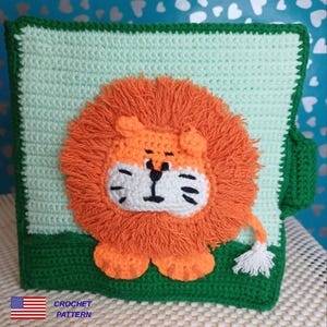 May include: A crocheted square featuring a lion design. The lion has an orange mane, a white face, and black details. The background is light green with a dark green border and base. The text "CROCHET PATTERN" is in the lower left corner.