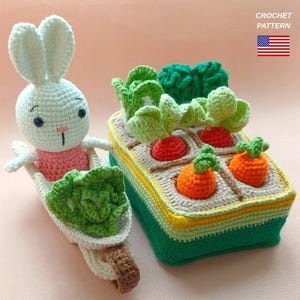 May include: Crocheted bunny with a pink shirt pushing a wheelbarrow filled with lettuce next to a crocheted garden box with carrots, radishes, and lettuce. The garden box is green, yellow, and beige. The text "CROCHET PATTERN" is in the upper right corner.