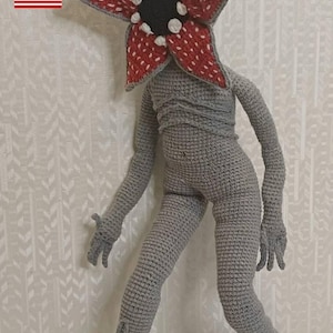 May include: A white ceramic mug with a black handle and the text "But first, coffee" in a black, handwritten-style font. The mug is on a white surface.