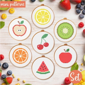May include: A set of seven cross-stitch patterns featuring various fruits, including a lemon, apple, kiwi, cherries, orange, watermelon, and a red apple. Each design is framed in a wooden hoop. The words "mini patterns" and "Set" are visible.