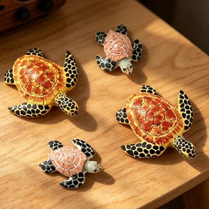 Peut inclure: Quatre figurines de tortues de mer de tailles variées. Deux grandes tortues présentent des carapaces jaune vif et orange avec des nageoires tachetées de noir. Deux petites tortues ont des carapaces pêche clair et des nageoires tachetées.