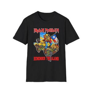 May include: A black short-sleeve t-shirt featuring a graphic of the Iron Maiden mascot Eddie standing over a map of Texas. The design includes the text Iron Maiden and Remember The Alamo, with a burning building and a Texas flag in the background.