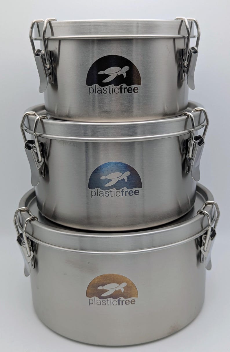 Three round stainless steel containers stacked by size