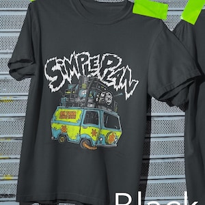 Può includere: T-shirt nero con una grafica colorata di un furgone carico di attrezzature, con il testo bianco "SIMPERIAN". Il furgone è blu e giallo con il testo "ON TOUR SINCE 1999".