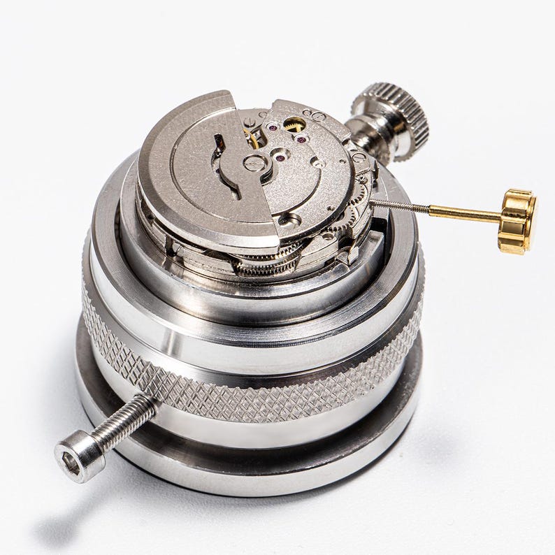 a close-up view of a mechanical device, likely a watch or clock mechanism, with various components and parts visible.