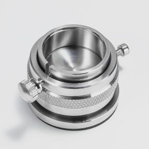 a close-up view of a metal object with a circular opening and two knobs on either side.