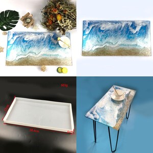 Puede incluir: Bandeja rectangular de resina con diseño de playa, con olas azules y blancas sobre una base arenosa. La bandeja se muestra con elementos decorativos y un molde rectangular blanco. La mesa mide 58,4 cm de largo, 37 cm de ancho y 6 cm de alto.