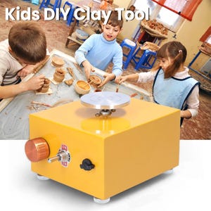 May include: A yellow electric pottery wheel for children featuring a circular silver turntable, a copper-coloured speed control knob, a metal toggle switch labelled ON and OFF, and a black power port on the front face of the rectangular base.