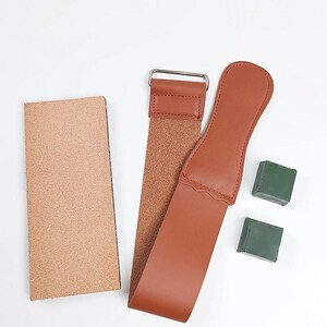 a brown leather strap, a small rectangular object, and two green objects on a white background.