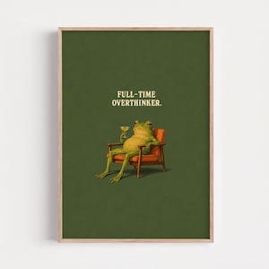 May include: A framed art print shows a frog in an armchair, holding a drink. The text "FULL-TIME OVERTHINKER" is displayed in a vintage font against a dark green background. The artwork has a humorous and whimsical theme, suitable for home decor.