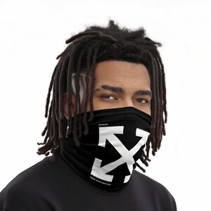 May include: Black face covering with a white arrow design. The face covering is worn around the neck and covers the nose and mouth. The text "PROTECTIVE MIND" is printed on the bottom of the face covering.