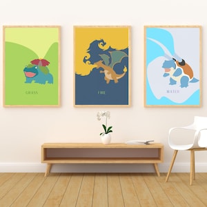 May include: Three framed art prints featuring stylized illustrations of a Grass, Fire, and Water type character. The prints have a minimalist design with solid color backgrounds and character silhouettes. Each print is labeled with its type.
