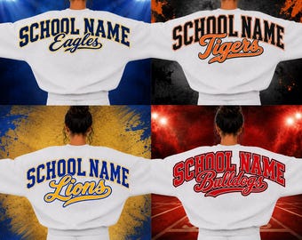 Puede incluir: Una sudadera blanca de cuello redondo con un diseño personalizado de estilo universitario en la espalda. El texto SCHOOL NAME está impreso en una fuente arqueada y negrita sobre un nombre de equipo, como Eagles, Tigers, Lions o Bulldogs.