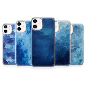 May include: A collection of five phone cases with various blue abstract designs. The cases have a clear border and feature different patterns, including brushstrokes and watercolor effects. The overall aesthetic is modern and artistic.