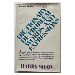May include: A vintage book titled "DICTIONARY OF PROBLEM WORDS AND EXPRESSIONS" with blue text on a white background. The book cover also includes the author's name, "HARRY SHAW", and the phrase "Revised Edition".