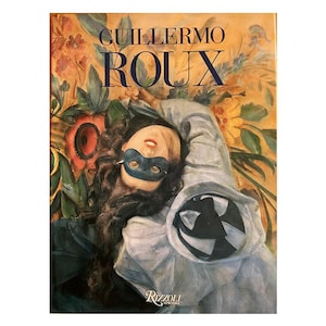 May include: A book cover featuring the title "GUILLERMO ROUX" in navy blue letters. The cover art depicts a woman wearing a blue mask, surrounded by floral elements. The Rizzoli New York logo is at the bottom.