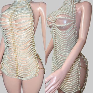 以下が含まれることがあります： ハイネックとオープンサイドのパールビーズドレス。ドレスは、多数の白い真珠のストランドと、金色のチェーンアクセントでできています。「DAINTY」と「LUXE」の文字が画像の下部にあります。