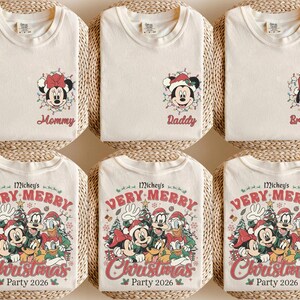 May include: Six cream-colored t-shirts featuring Disney character graphics. The top row shows individual character faces with text reading Mommy, Daddy, and Brother. The bottom row displays a group holiday scene with text reading Mickey's Very Merry Christmas Party 2026.