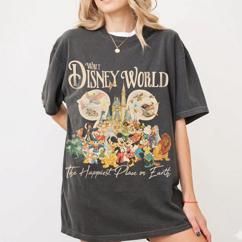 May include: Dark gray t-shirt featuring a colorful graphic of Disney characters and the text "Walt Disney World" and "The Happiest Place on Earth." The design includes Mickey Mouse, Donald Duck, and other beloved characters.