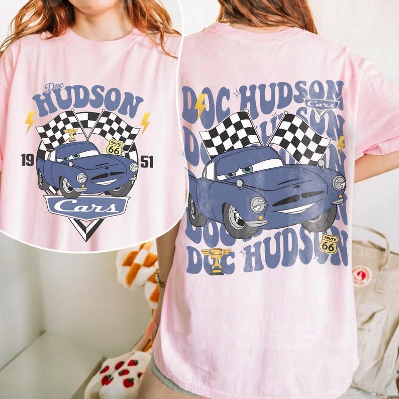 May include: A white ceramic mug with a black handle and the text "But First, Coffee" in a black, handwritten-style font. The mug is on a white surface.