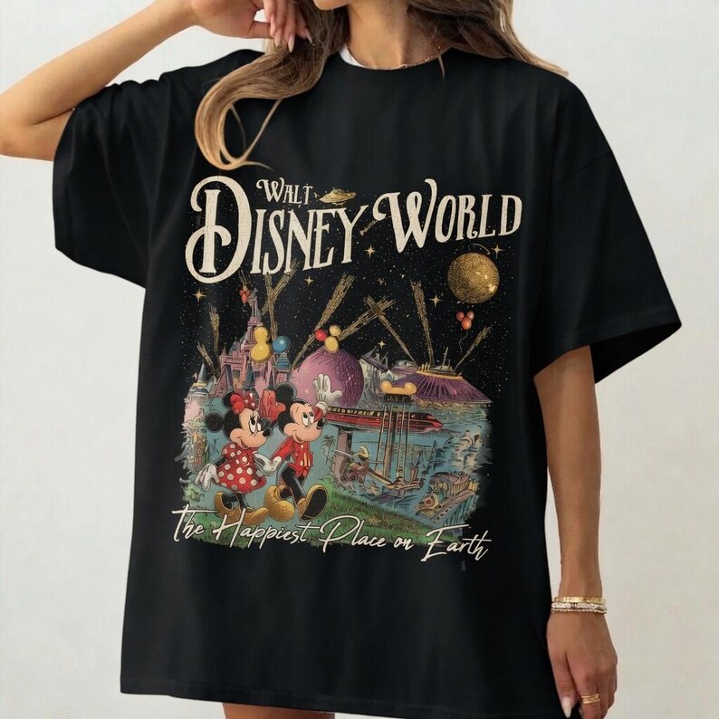 May include: Black t-shirt featuring a colorful graphic of Mickey and Minnie Mouse at Disney World. The design includes the text "Walt Disney World" and "The Happiest Place on Earth" in a vintage style. The shirt is a classic crew neck.