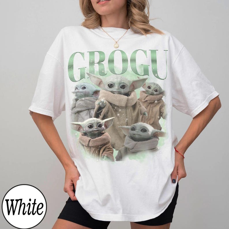 May include: White t-shirt featuring a graphic of Grogu, also known as Baby Yoda, from The Mandalorian. The word "GROGU" is printed in green above the image of Grogu. The t-shirt is a casual, oversized style.