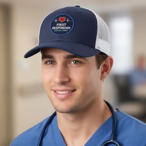 Könnte beinhalten: Eine marineblaue und weiße Trucker-Cap mit einem runden Aufnäher auf der Vorderseite. Der Aufnäher zeigt ein rotes Herz mit einer EKG-Linie sowie den Text FIRST RESPONDER und EVERY DAY COUNTS in weißer Schrift auf dunkelblauem Grund.