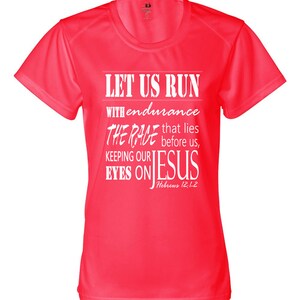 May include: A bright pink athletic t-shirt with a white graphic that reads "Let us run with endurance the race that lies before us, keeping our eyes on Jesus, Hebrews 12:12".